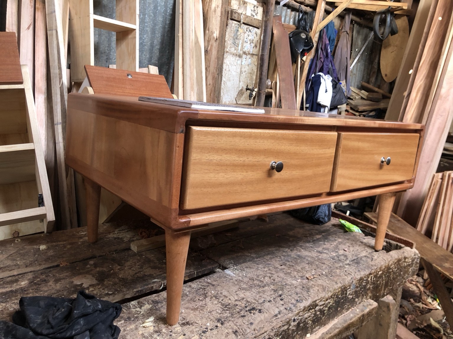 Polished timber table with two drawers, round knobs and tapered legs